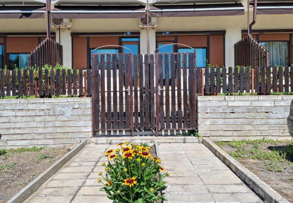 a fence with a flower bed in front of a house at TRS Apartments in Sozopol