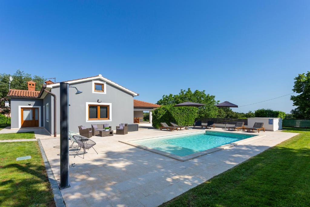 a backyard with a swimming pool and a house at Villa Anavi in Bičići