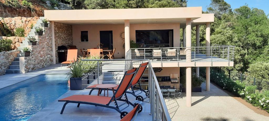 una casa con 2 sillas en un balcón con piscina en Les Hauts du Peireguier en La Motte