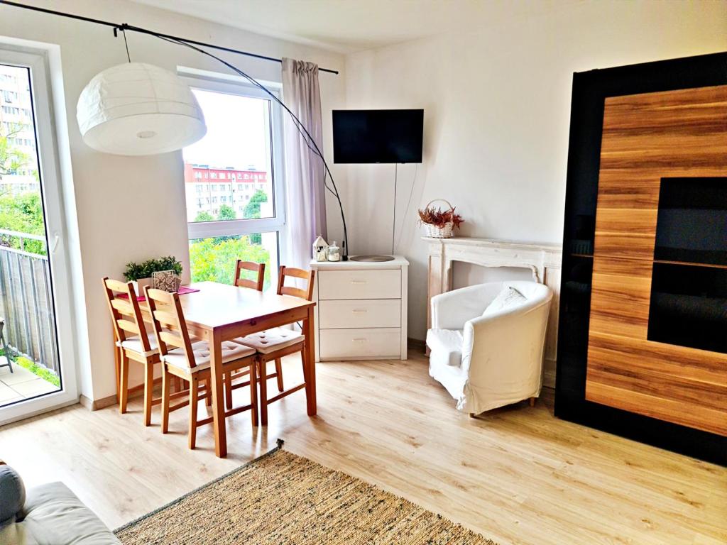 uma sala de estar com mesa e cadeiras e um quarto com lareira em Portowy - Sweet House em Świnoujście
