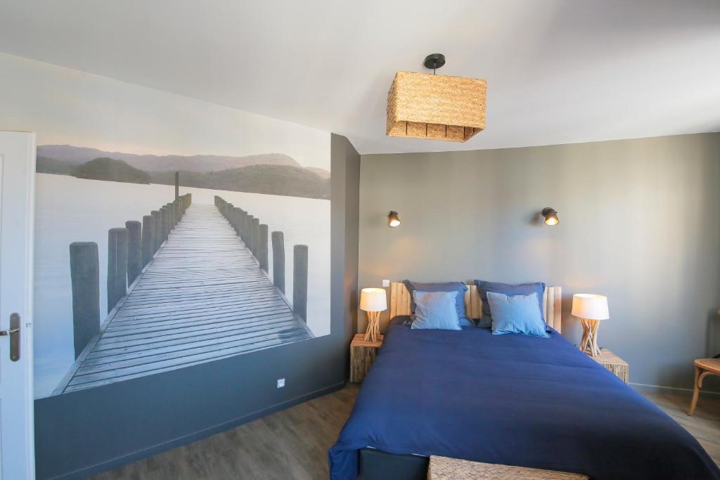 sypialnia z niebieskim łóżkiem i obrazem molo w obiekcie Le Bois, T2 hypercentre chic et cosy, Wifi par SOVALFI w mieście Saint-Étienne