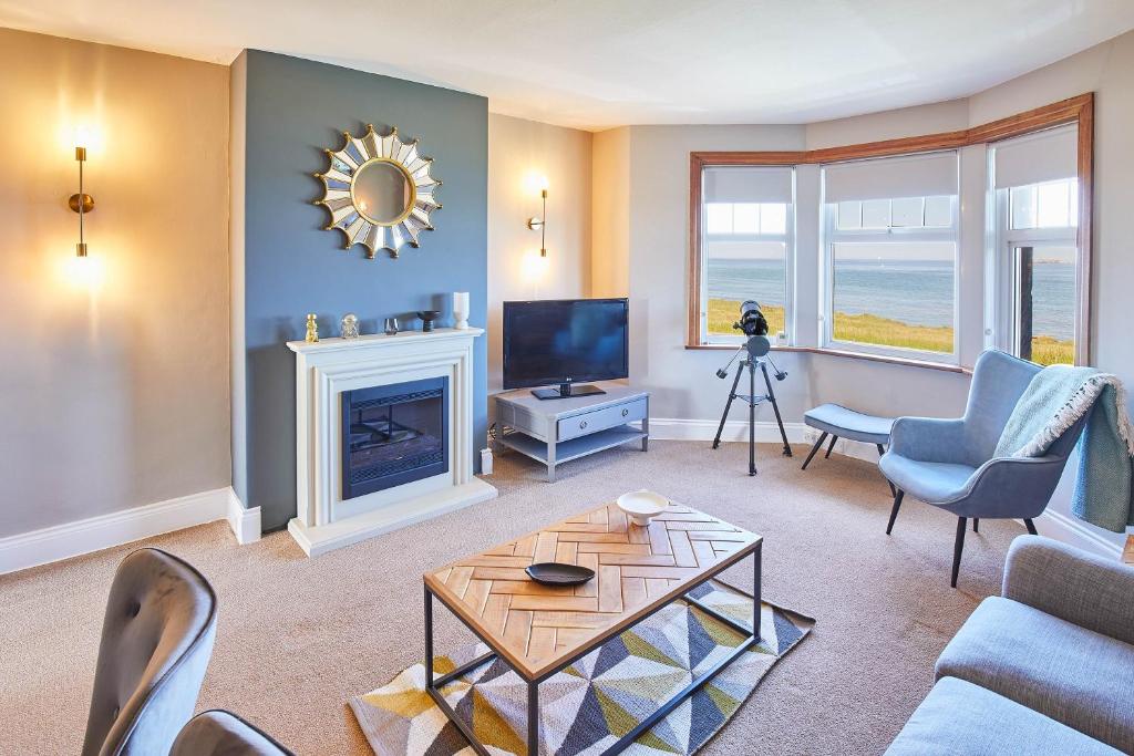 a living room with a fireplace and a television at Host & Stay - The Puffins Nest in Seahouses