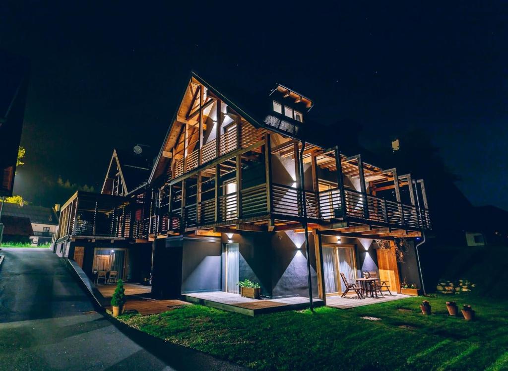 una gran casa de madera iluminada por la noche en Chalet Valcanale, en Camporosso in Valcanale