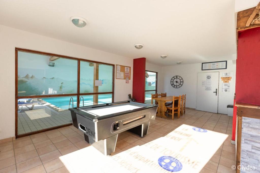 a dining room with a pool table and a ping pong ball at Olydea Fontaine du Roi in Saint-Jean-dʼArves