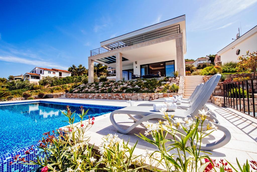 a villa with a swimming pool and a house at Villas Anita in Veli Iž