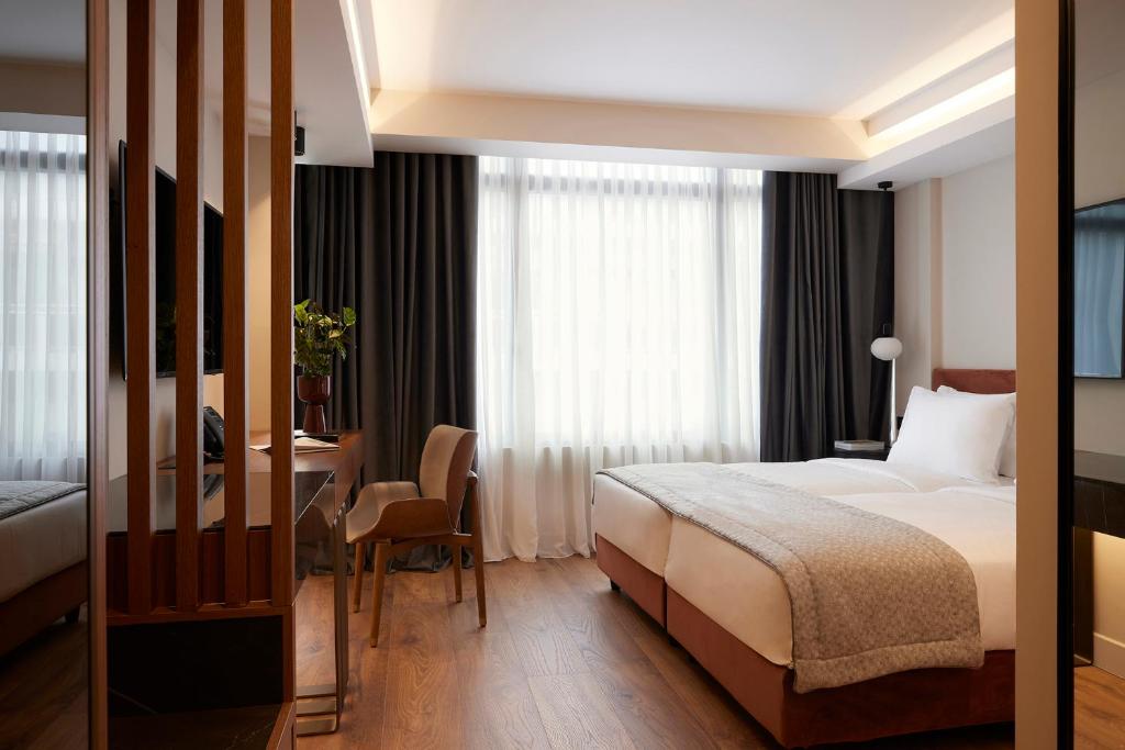 a hotel room with a bed and a table and a desk at Teight Hotel in Thessaloniki