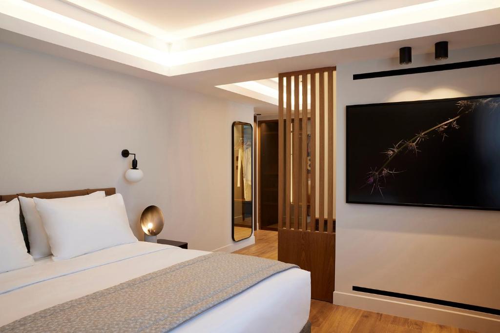 a bedroom with a bed with a large television on the wall at Teight Hotel in Thessaloniki