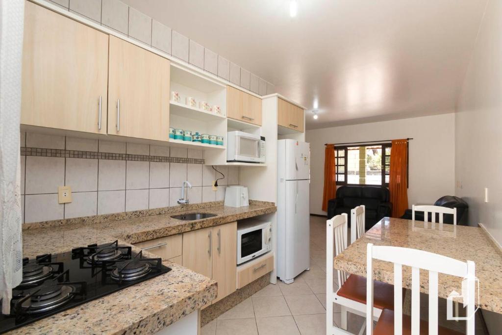 a kitchen with a stove and a counter top at Casa térrea com 03 dormitórios perfeita para seus dias de férias na praia in Bombinhas