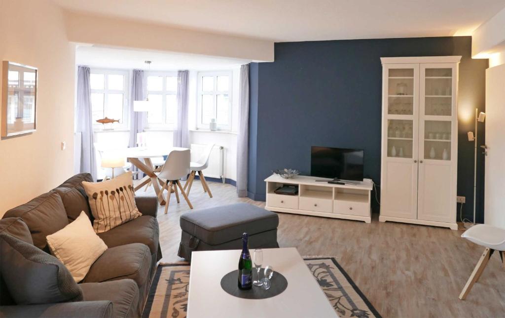 ein Wohnzimmer mit einem Sofa und einem TV in der Unterkunft Strandburg Juist - Turmwohnung 105 (Ref. 50957) in Juist