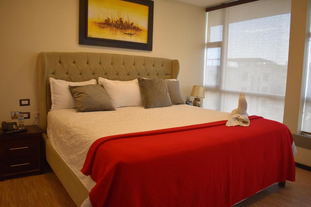 a bedroom with a large bed with a red blanket at HOTEL OCEANIK in Manta