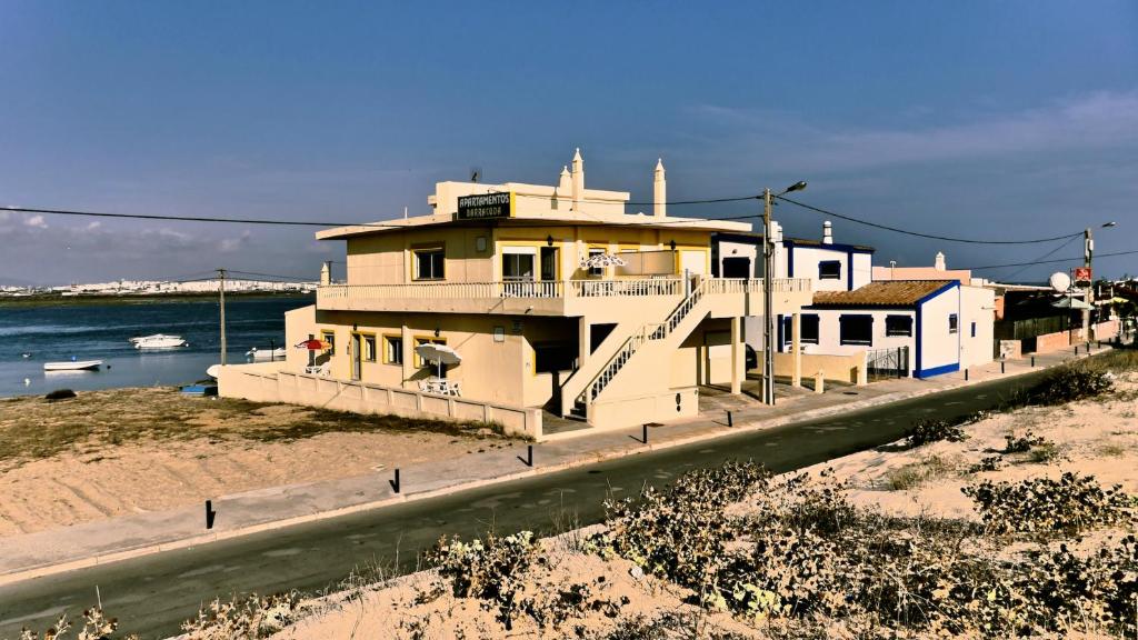 una casa al lado de una carretera al lado del océano en Apartamentos Barracuda, en Faro