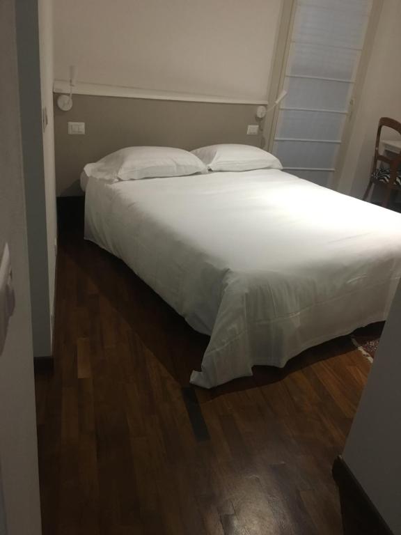 a bedroom with a large bed with white sheets and pillows at La Pallanzotta in Verbania