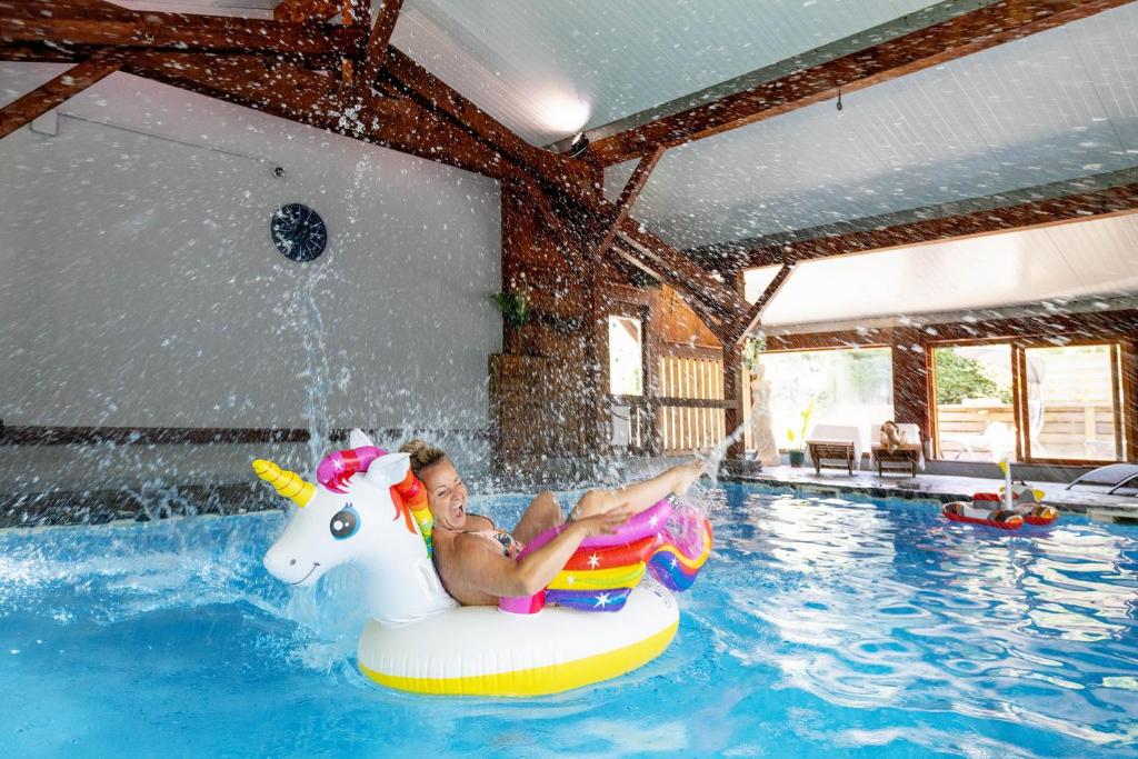 Una donna che cavalca un unicorno in una piscina di Fontaine du Mont Blanc Hotel & Spa a Les Houches