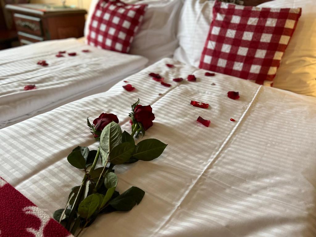 a couple of beds with roses on them at Hotel Fassbind Beausite in Beatenberg