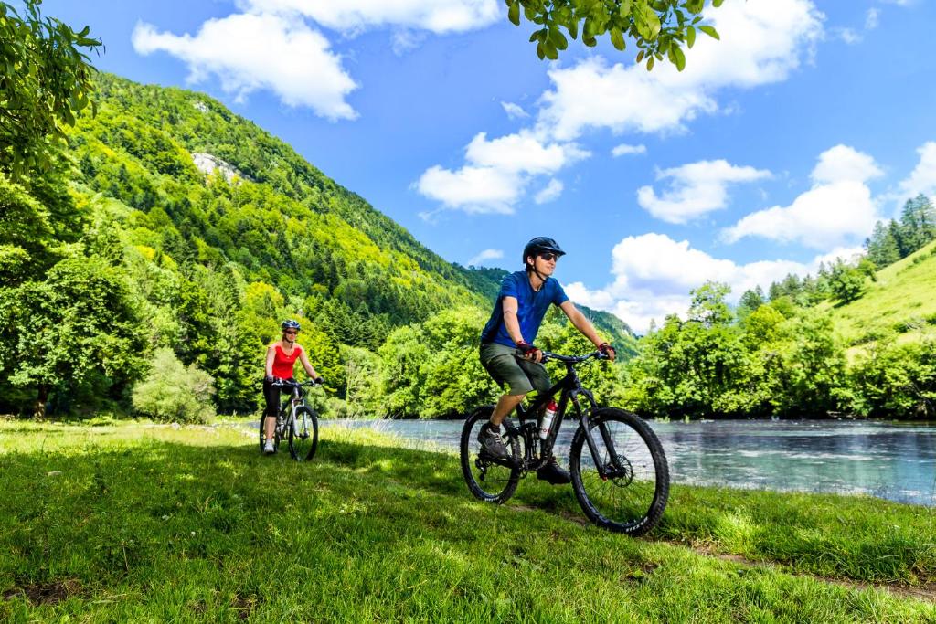 a man and a child riding bikes next to a river at Peanut Medieval Lodge in Saint-Ursanne