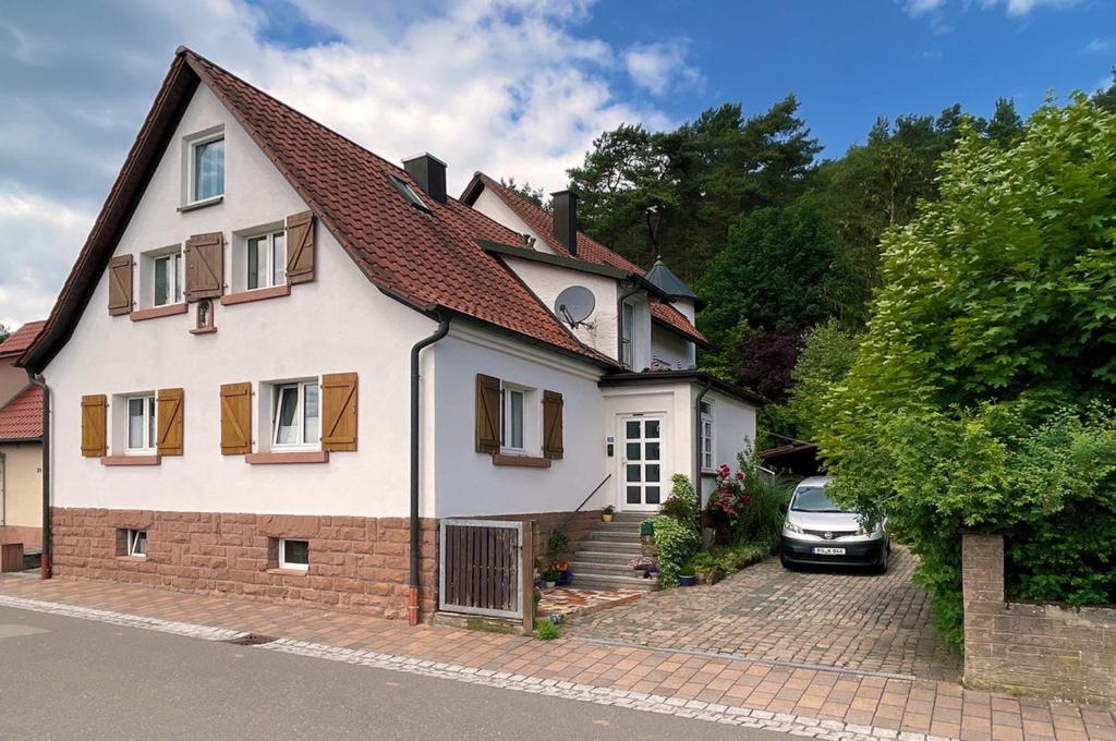 a white house with a car parked in front of it at Lieselhaus in Busenberg