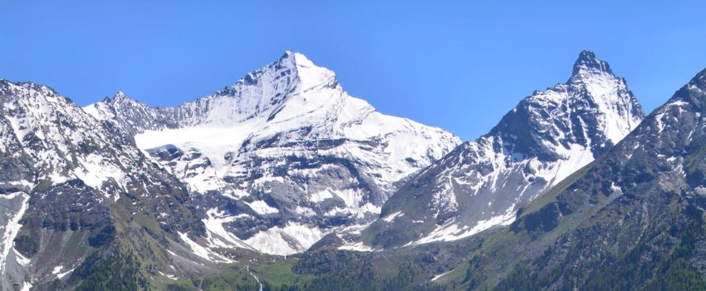 um grupo de montanhas com neve sobre eles em Val di Cogne Il Grand Nomenon em Aymavilles