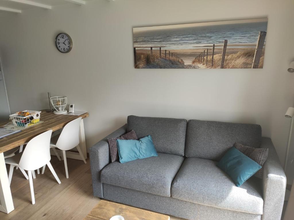 a living room with a couch and a dining table at SeaLodge4you in Bredene