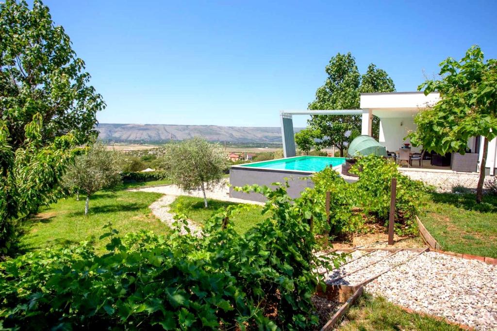 a villa with a garden and a swimming pool at Villa Mona ,heated swimming pool in Mostar