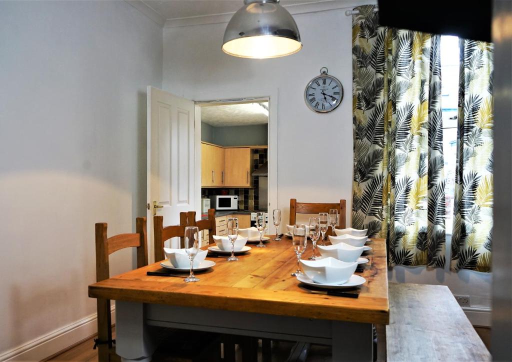 een eetkamer met een tafel met stoelen en een klok bij Nineteen in Bridlington