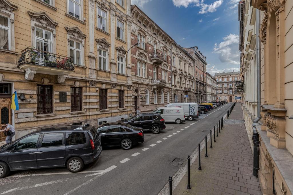 a row of cars parked on a city street at Parkside Fresh Apartments - Old Town Guesthouse in Krakow