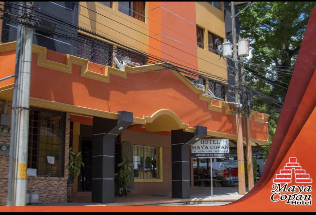 an orange and yellow building with a sign in front of it at Hotel Maya Copan Guamilito in San Pedro Sula