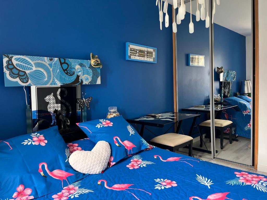 niebieska sypialnia z łóżkiem i lustrem w obiekcie ELLO HAPPINESS HOME place to be in pau w mieście Pau