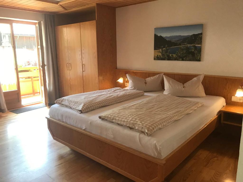 a bedroom with a large bed with two pillows at Haus Petra in Oberjoch