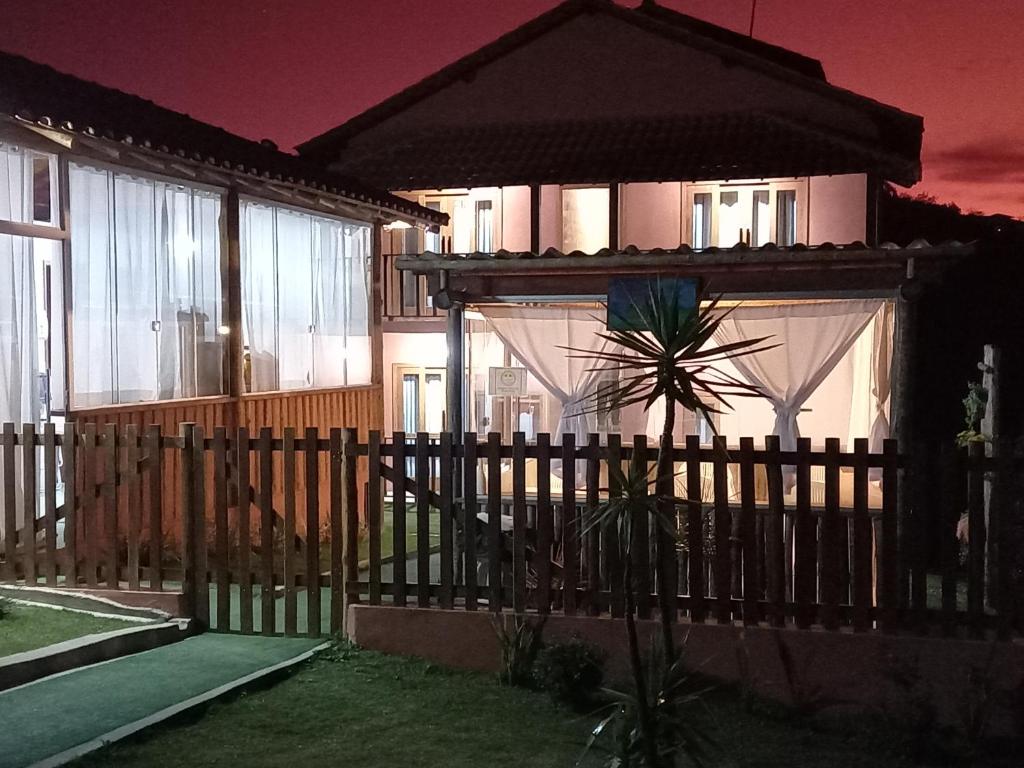 une clôture devant une maison avec un parasol dans l'établissement SERRA DA NEBLINA, à Lavras Novas