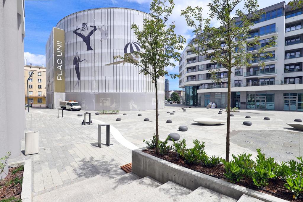 a building with a courtyard with trees in front of it at Plac Unii Apartment Gdynia by Renters in Gdynia