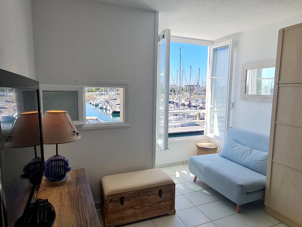 un salon avec un canapé bleu et une fenêtre dans l'établissement REF 040 - Studio moderne et rénové pour quatre personnes vue port Crouesty ARZON, à Arzon
