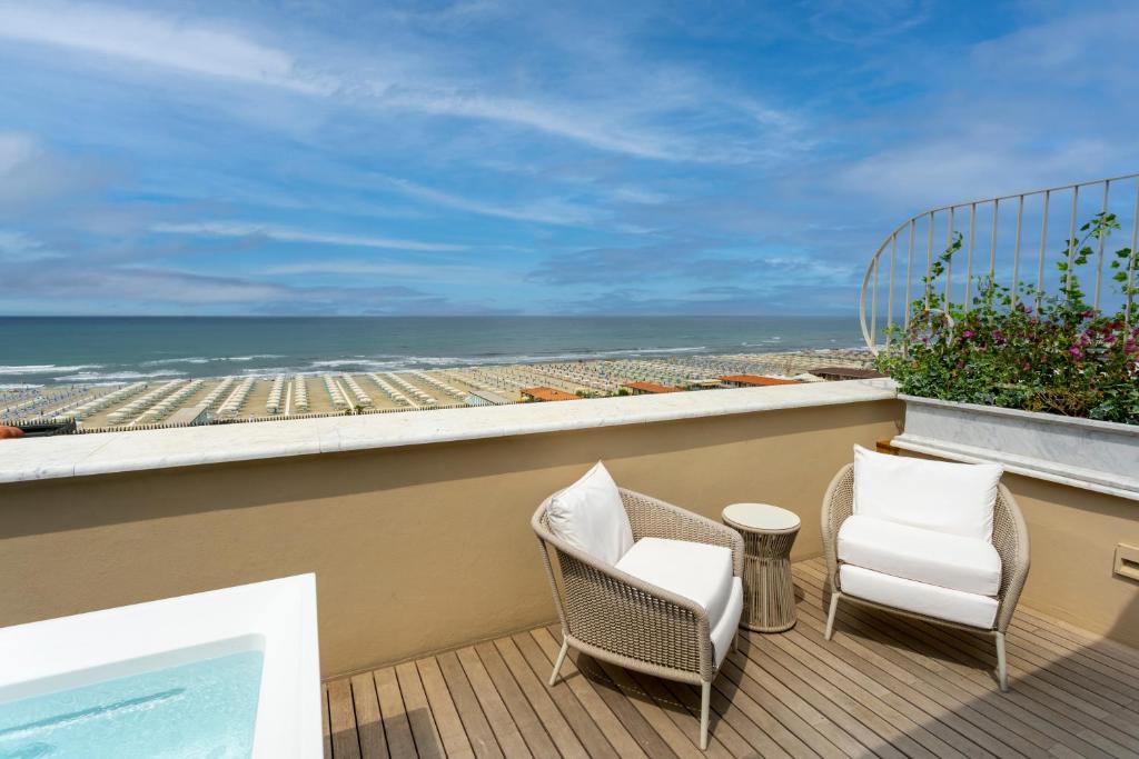 a balcony with two chairs and a view of the ocean at Grand Hotel Principe Di Piemonte in Viareggio