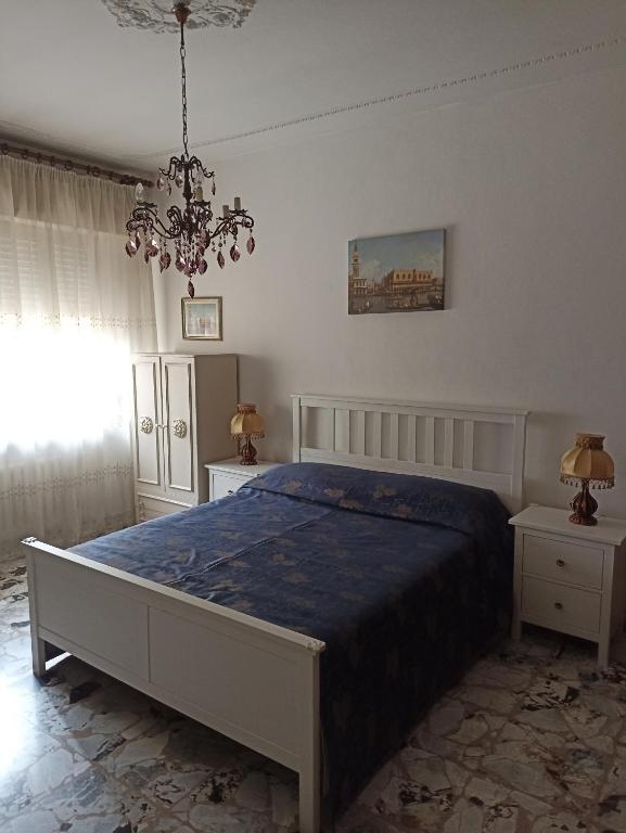 sypialnia z łóżkiem i żyrandolem w obiekcie Alba sul mare w mieście Porto Recanati