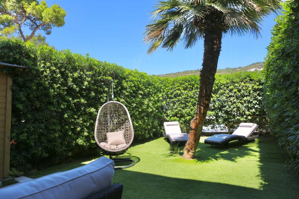 een tuin met een hangmat en een palmboom bij Butique apartment Loggia in Dubrovnik