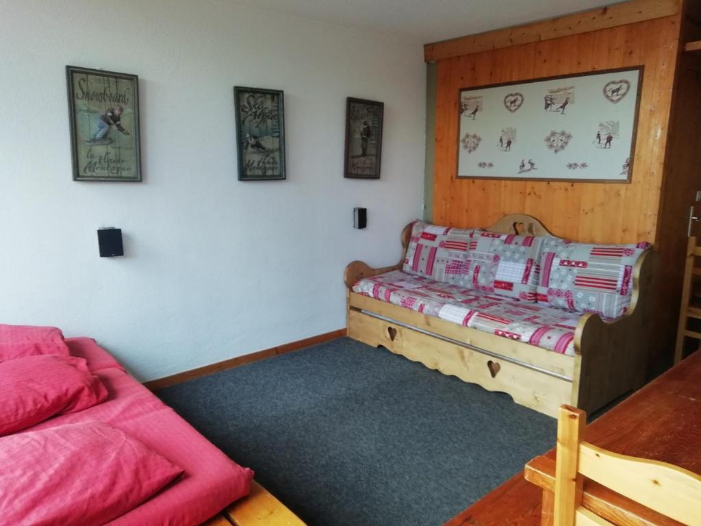 - une chambre avec un lit et un canapé rouge dans l'établissement Studio spacieux à Arc 1600 avec balcon, télé, wifi et animaux acceptés - FR-1-411-454, à Arc 1600