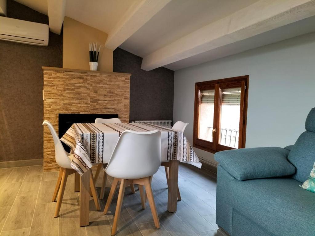 a dining room with a table and chairs and a fireplace at Casa Garí in Horta de San Joan