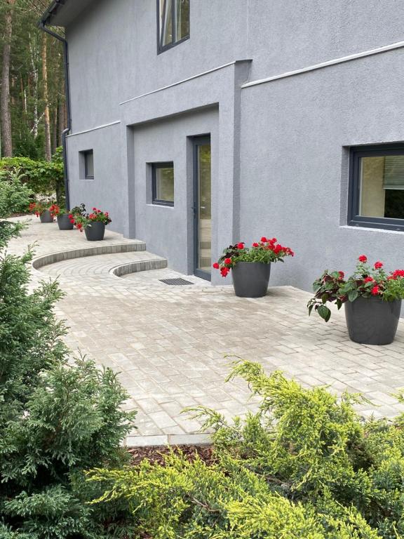 a building with pots of flowers in front of it at 9 Mežmalas iela in Jūrmala