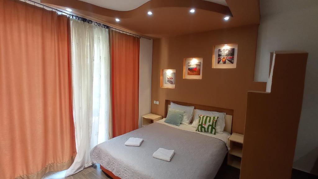 a bedroom with a bed and a large window at Apartments Radovic in Petrovac na Moru