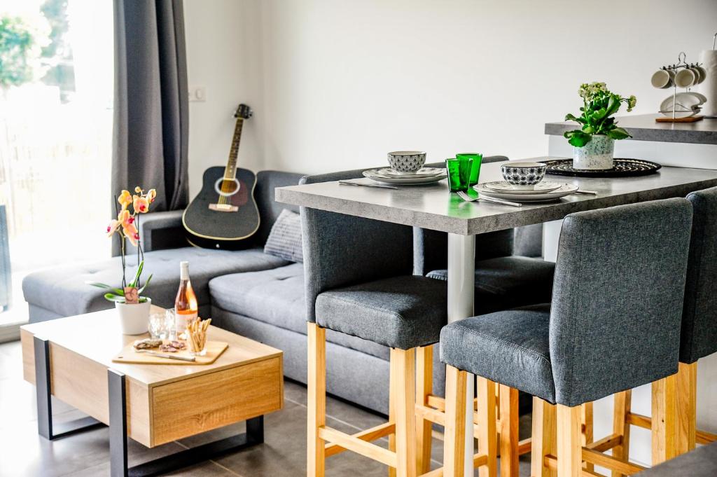 a living room with a table and chairs and a couch at FRANCESCA, Plage à pied, Terrasse, Clim - Porticcio in Porticcio