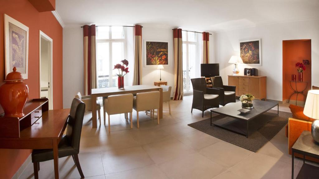 Una sala de estar con una mesa y un comedor. en Cannes Croisette Prestige Apart'hotel, en Cannes