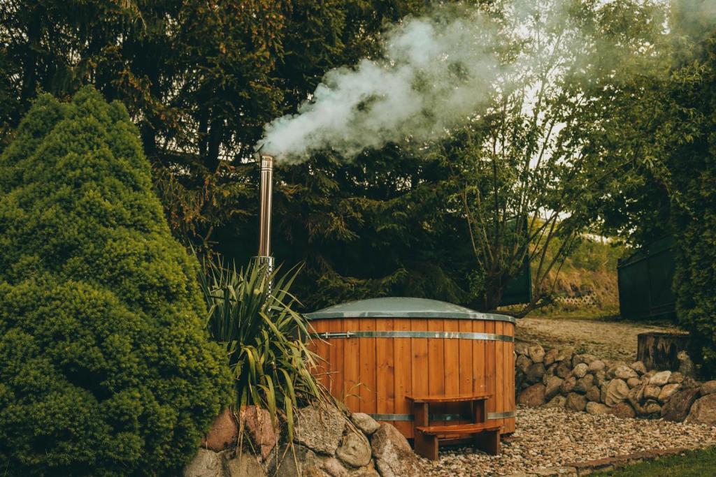 una pequeña cabaña de madera con humo saliendo de ella en Na Soltyskiej en Mrągowo