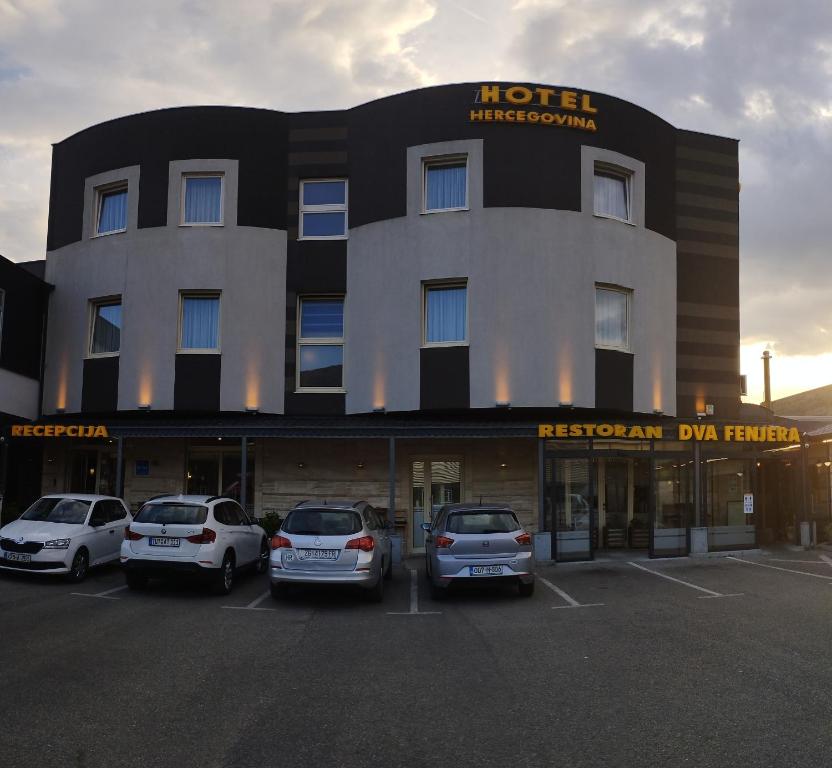 un hôtel avec des voitures garées dans un parking dans l'établissement Hotel Hercegovina, à Mostar