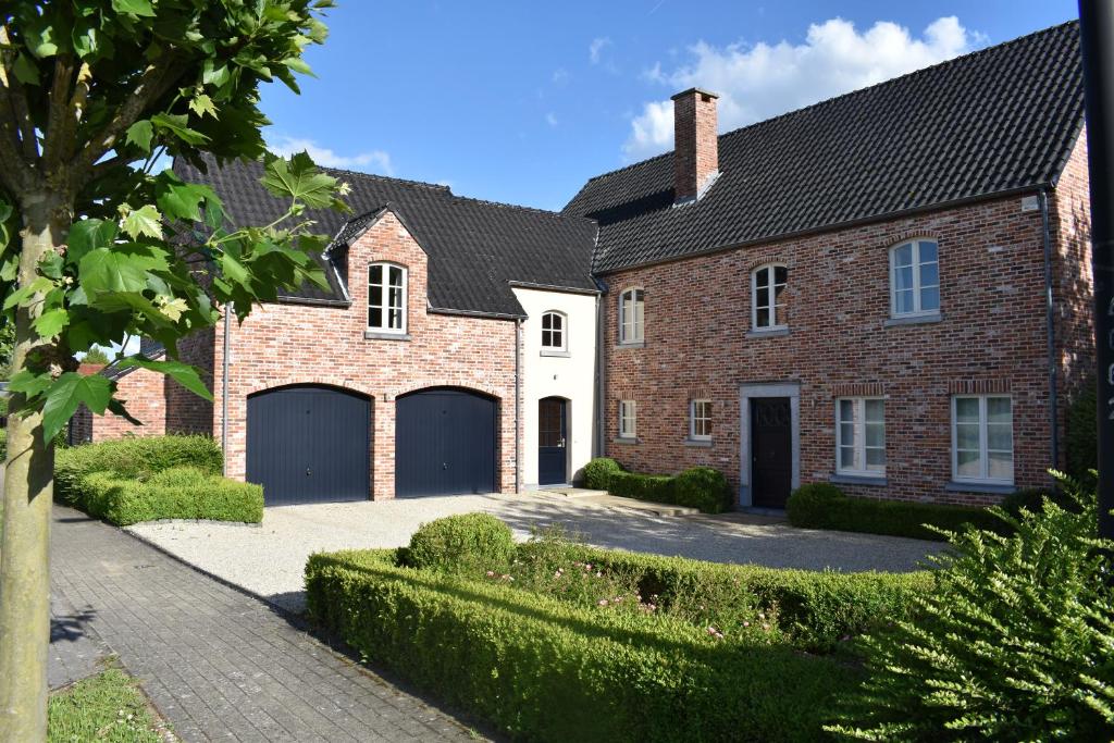 a large brick house with a garage at Le Verger du Patagon in Rofessart