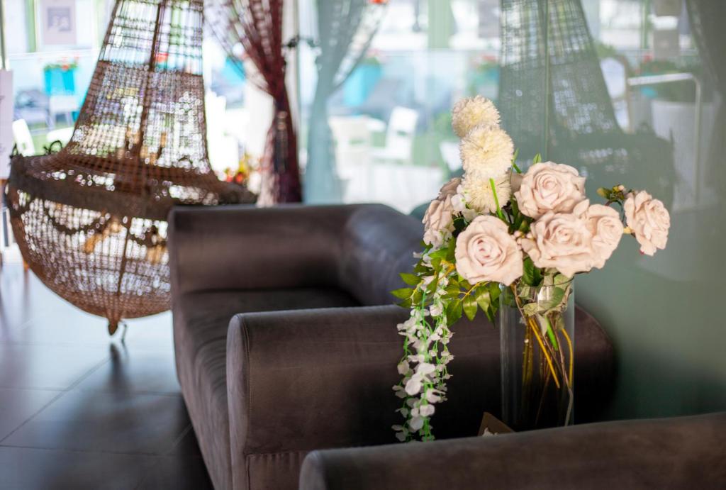 eine Vase voller Blumen auf einer Couch in der Unterkunft SALOU 4 YOU apartamentos in Salou