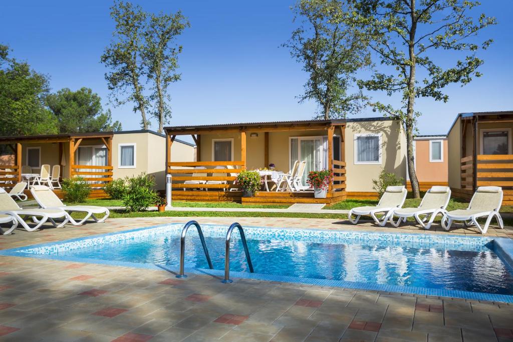 una casa con piscina frente a una casa en Maistra Camping Valkanela Mobile homes en Funtana