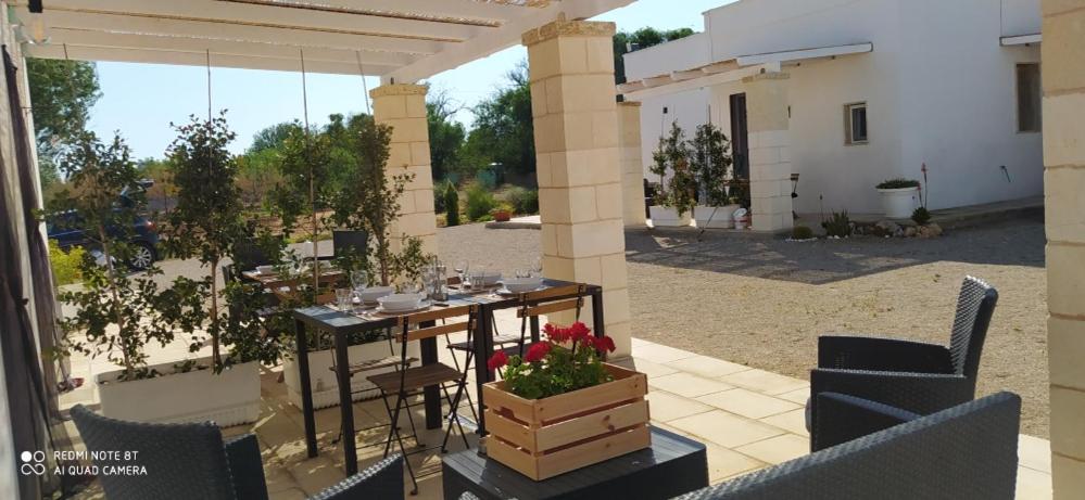 eine Terrasse mit einem Tisch und Stühlen sowie ein Gebäude in der Unterkunft Dimora Monsignore in Torre Lapillo