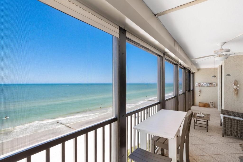a balcony with a table and views of the beach at #504 Shores of Madeira in St Pete Beach