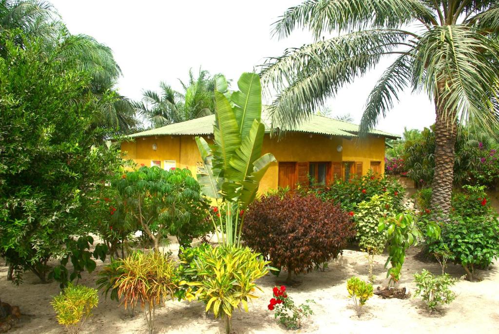 a house with trees and plants in front of it at Bolongs Passion in Cap Skirring