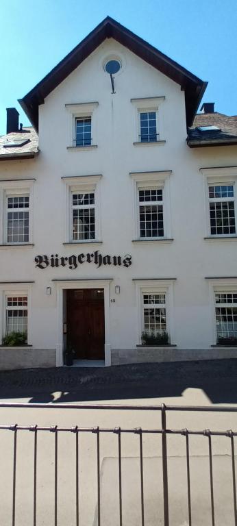 a white building with a gate in front of it at Buergerhaus Zeltingen Fewo in Zeltingen-Rachtig