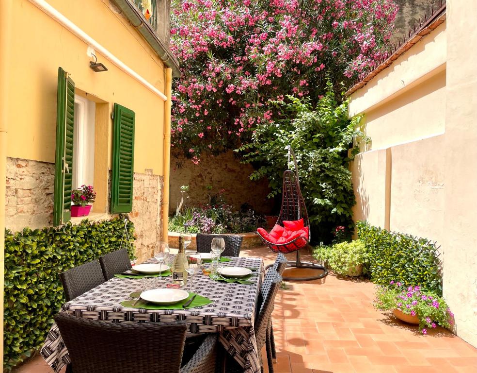 una mesa y sillas en un patio con flores en Santa Croce Garden Apartment en Florencia